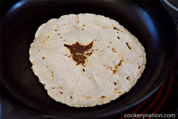 When the underside is browned, flip one more time. You will notice that the tortilla will puff slightly. Allow 20 seconds - 1 minute to brown the first side a bit more. When you remove the tortilla, it will feel quite hard. Don't worry, it will soften.